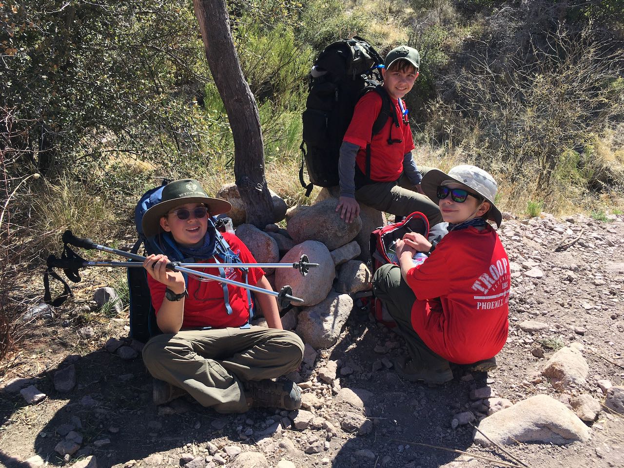 3 scouts sitting on trail